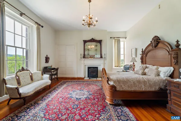 a bedroom with a bed chandelier and dresser