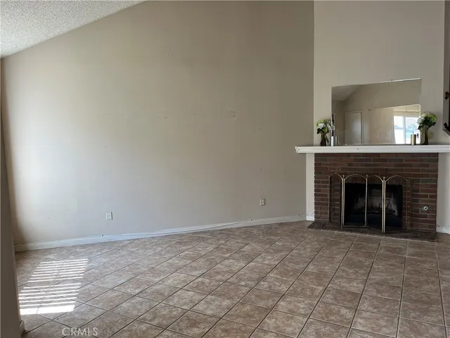 a view of an empty room with window and fire place