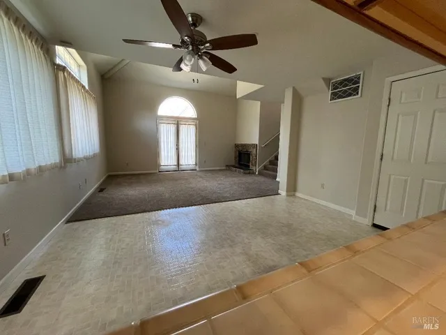 a view of a livingroom with a ceiling fan and window