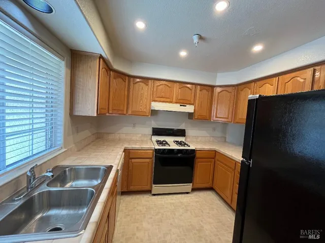 a kitchen with stainless steel appliances granite countertop a sink stove and refrigerator