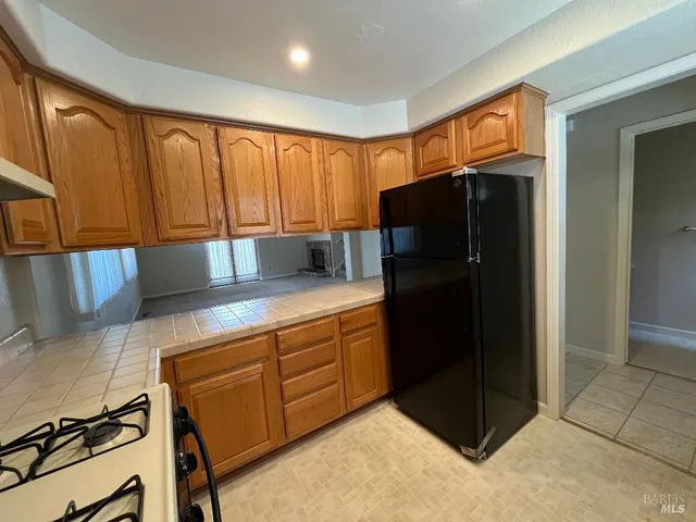 a kitchen with stainless steel appliances granite countertop a refrigerator and a stove top oven