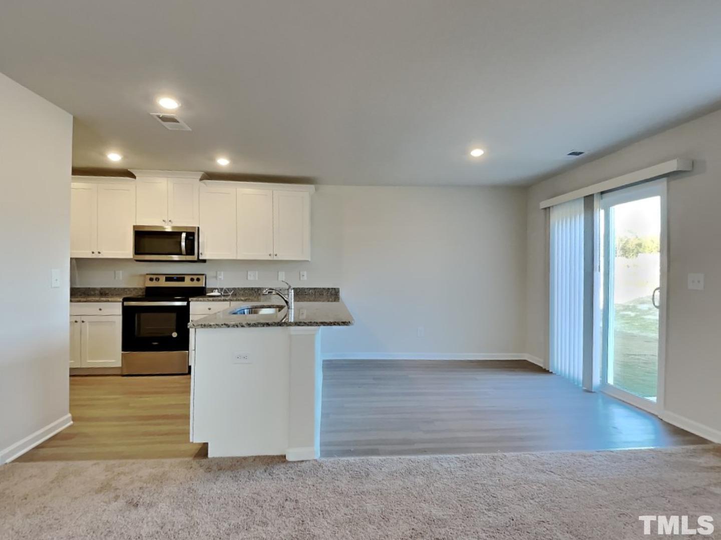 73 Barnsley Road Angier, NC 27501 - Photo 2 of 18 a kitchen with stainless steel appliances kitchen island granite countertop a stove a sink and a refrigerator