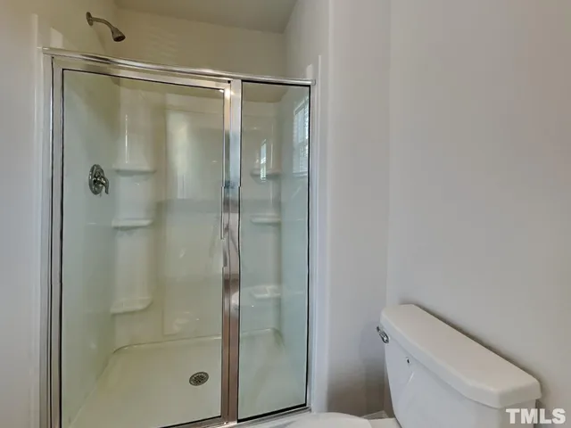 a bathroom with a shower a toilet and a sink