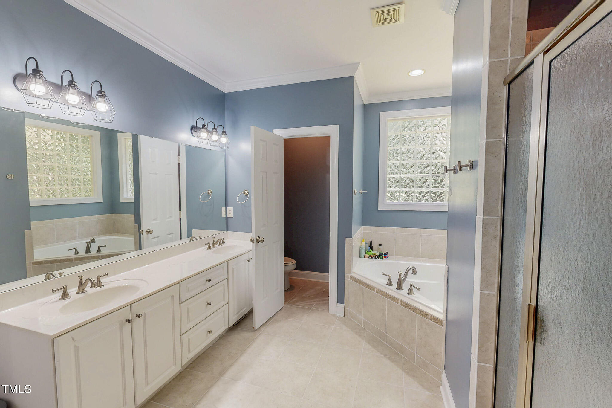 476 North Old Lantern Road Timberlake, NC 27583 - Photo 24 of 50 a bathroom with a double vanity sink a large mirror and a bathtub