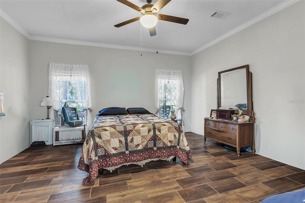 601 Purvis Road Seville, FL 32190 - Photo 27 of 29 a bedroom with a bed and wooden floor