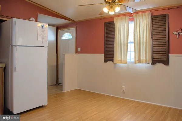 a view of empty room with window and refrigerator