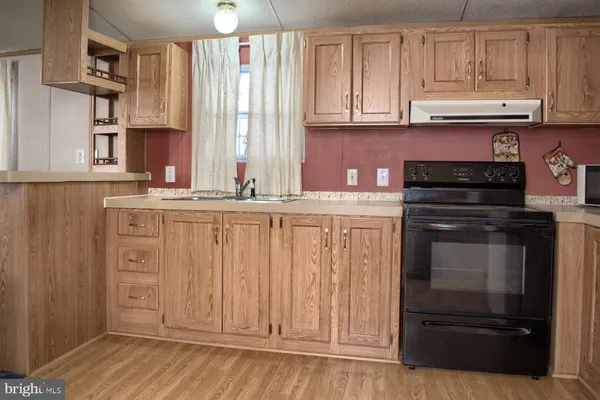 a kitchen with granite countertop cabinets stainless steel appliances and a window