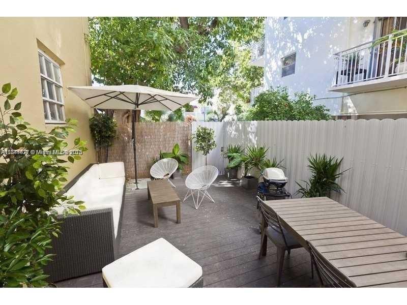439 15th Street, Unit 15 Miami Beach, FL 33139 - Photo 1 of 13 a backyard of a house with table and chairs