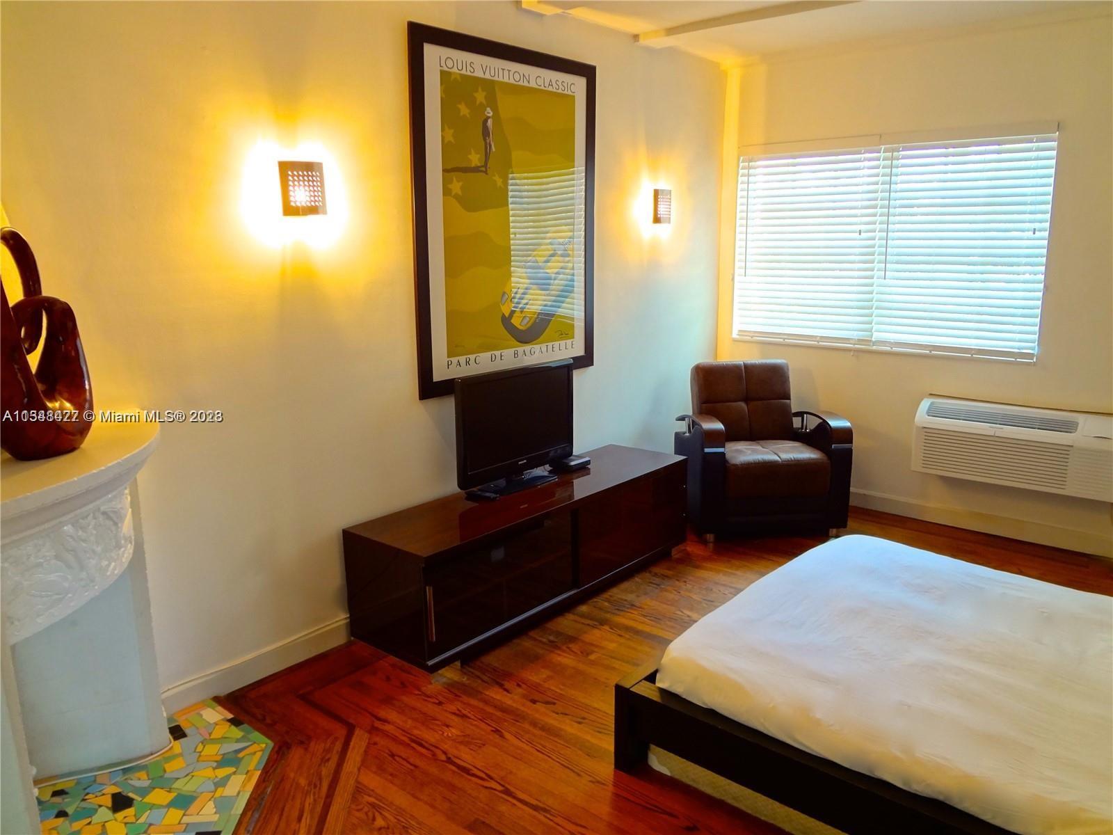 439 15th Street, Unit 15 Miami Beach, FL 33139 - Photo 6 of 13 a bedroom with a bed and wooden floor