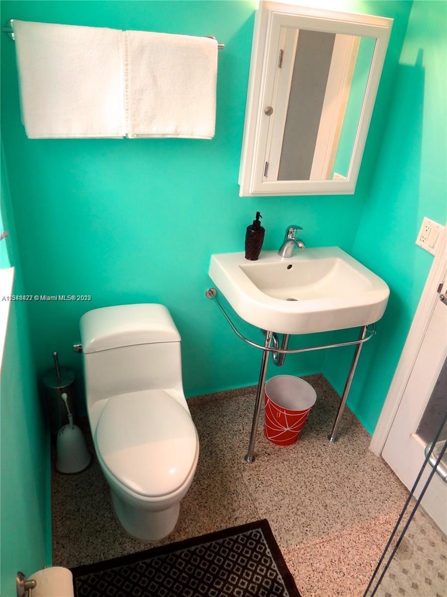 439 15th Street, Unit 15 Miami Beach, FL 33139 - Photo 8 of 13 a bathroom with a toilet a sink and mirror