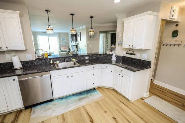 a kitchen with cabinets appliances and a wooden floor
