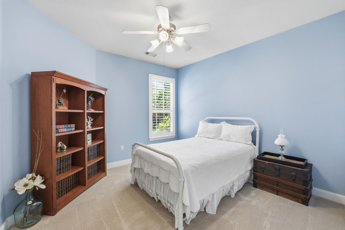 99 Bagpipe Way Conroe, TX 77384 - Photo 19 of 40 a bedroom with a bed and a chandelier