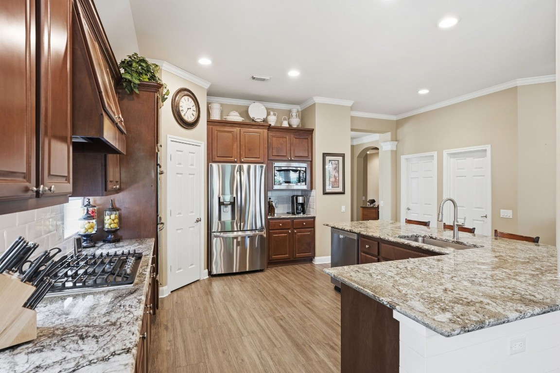 99 Bagpipe Way Conroe, TX 77384 - Photo 6 of 40 a kitchen with stainless steel appliances granite countertop a sink stove and refrigerator