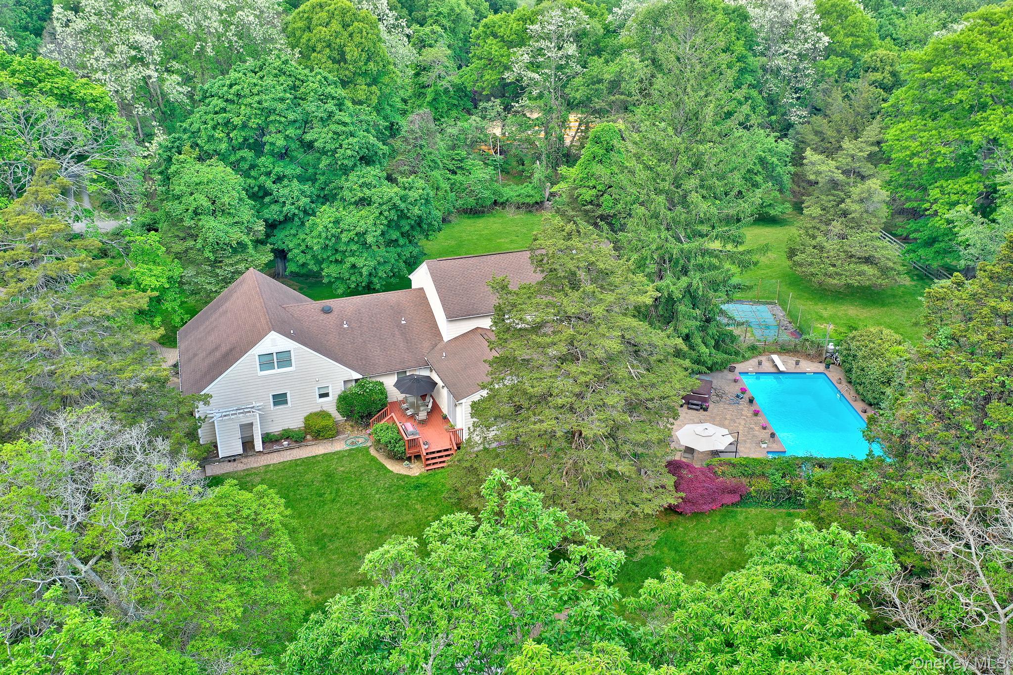 15 Stillwater Road Nissequogue, NY 11780 - Photo 34 of 43 Expansive property featuring a multi-level home with a private swimming pool, surrounding patio, and a dedicated sports court