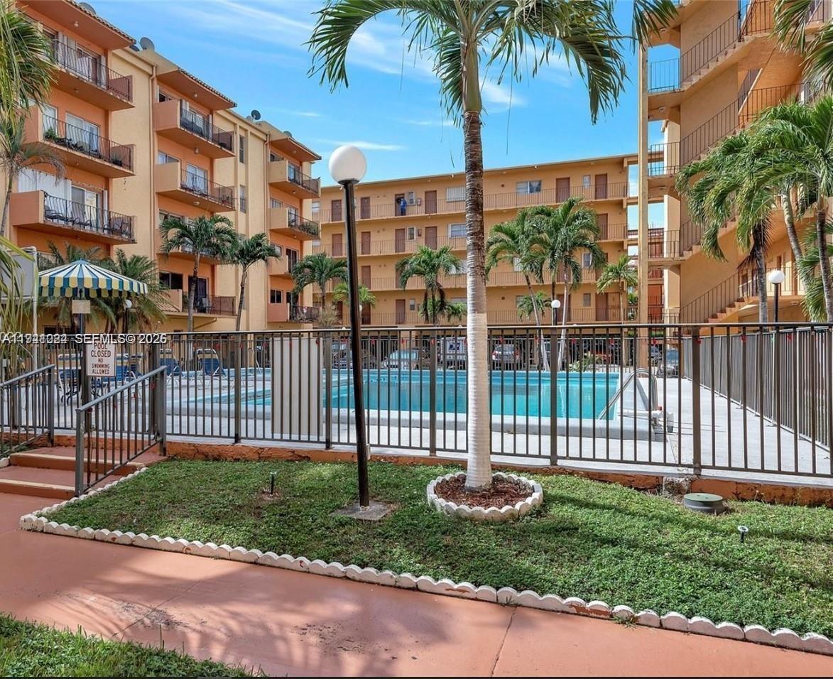 1900 West 54th Street, Unit 307 Hialeah, FL 33012 - Photo 2 of 7 a view of a brick house with a yard and plants