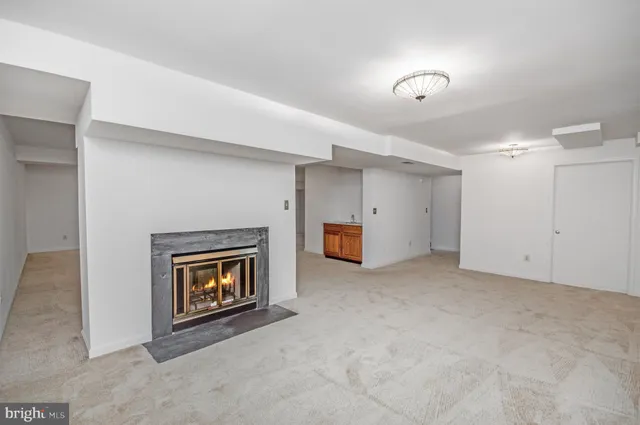 a view of an empty room with a fireplace and a window