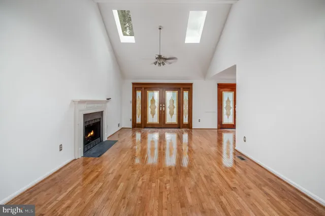 a view of empty room with wooden floor and fireplace