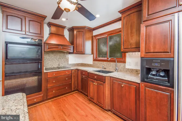 a kitchen with stainless steel appliances granite countertop a sink and wooden cabinets
