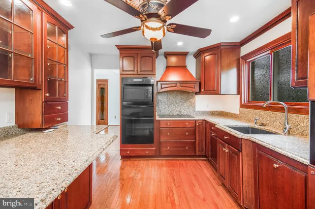 a kitchen with stainless steel appliances granite countertop a sink and wooden cabinets