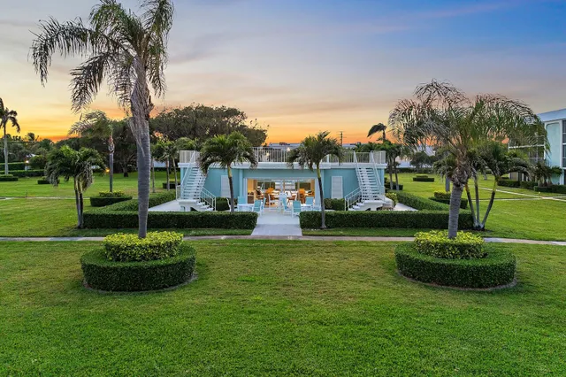 an aerial view of a residential houses with outdoor space and ocean view