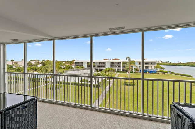 an aerial view of residential houses with outdoor space and ocean view