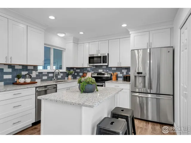 a kitchen with refrigerator a microwave a stove and white cabinets