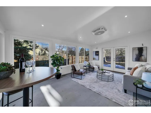 a living room with furniture and potted plants