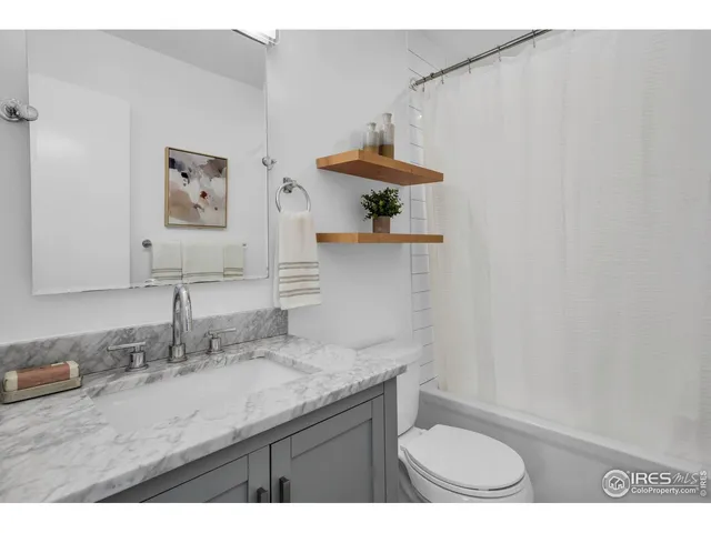 a bathroom with a granite countertop sink a toilet and a mirror