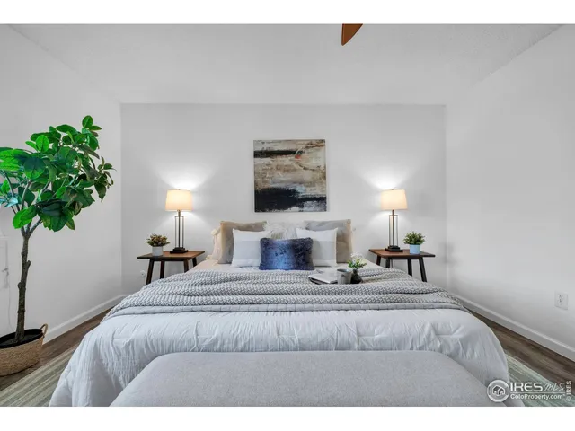 a bedroom with a bed lamp and a potted plant