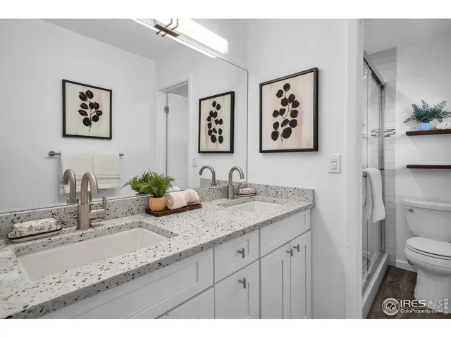 a bathroom with a granite countertop sink and a toilet