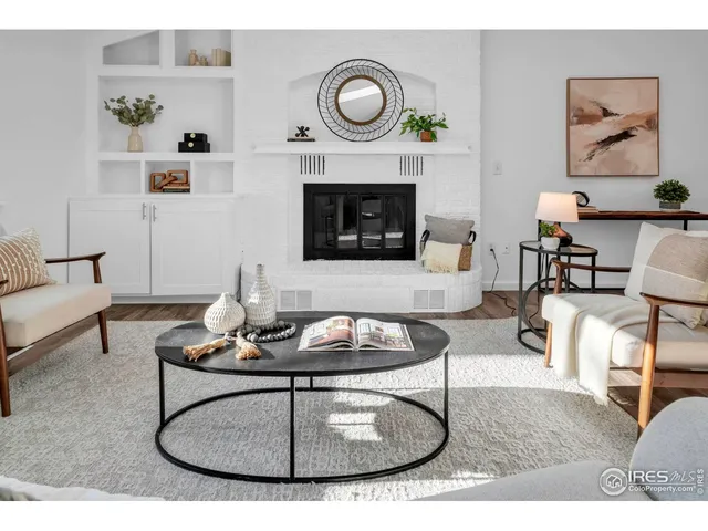 a living room with furniture a fireplace and wall paintings