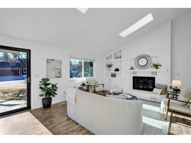 a living room with furniture a fireplace and a potted plant