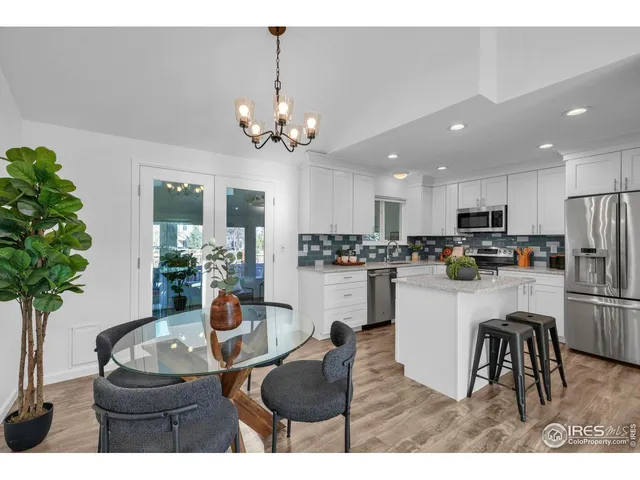 a living room with stainless steel appliances kitchen island furniture and a chandelier