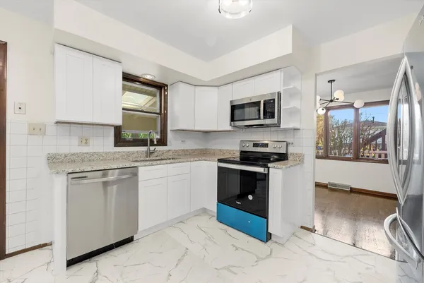 a large white kitchen with a sink and cabinets