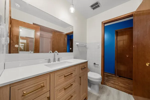 a bathroom with a granite countertop sink toilet and shower