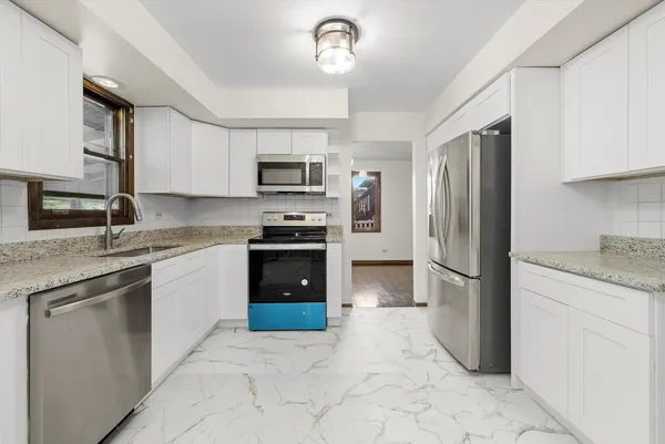 a kitchen with granite countertop a stove top oven microwave and sink
