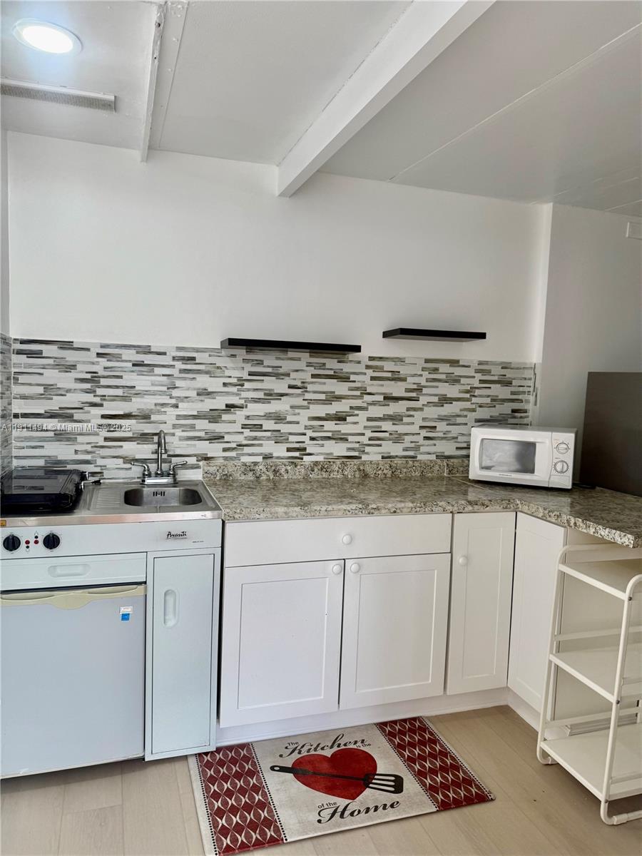 13008 Southwest 50th Lane, Unit 13008 Miami, FL 33175 - Photo 2 of 12 a kitchen with stainless steel appliances granite countertop a sink stove and cabinets