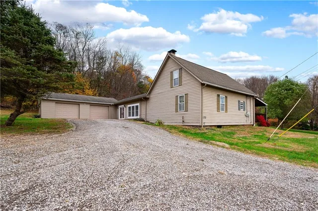 a view of a house with backyard and trees
