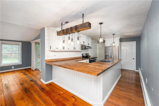 a kitchen with stainless steel appliances granite countertop a sink a stove and a refrigerator