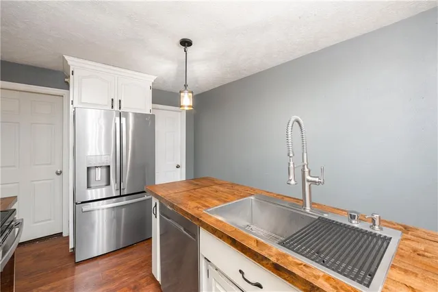 a kitchen with kitchen island a counter top space cabinets and stainless steel appliances