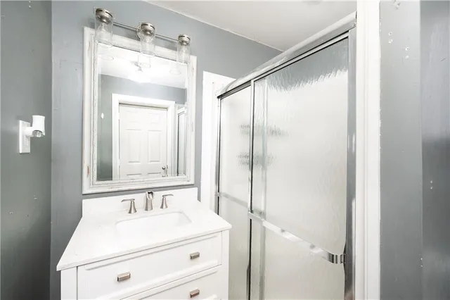 a bathroom with a sink a mirror and a shower