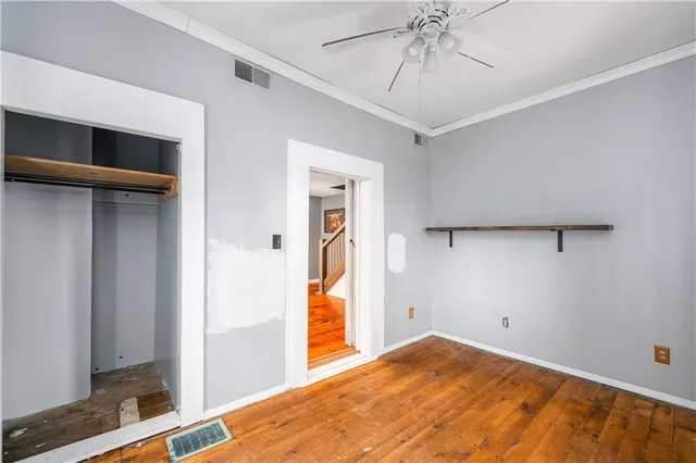 a view of a livingroom with a chandelier fan and wooden floor