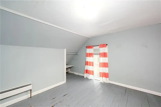 an empty room with wooden floor and cabinets