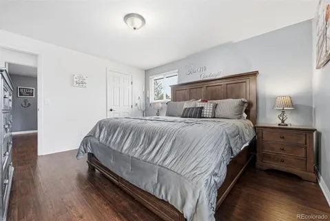 a bedroom with bed and wooden floor
