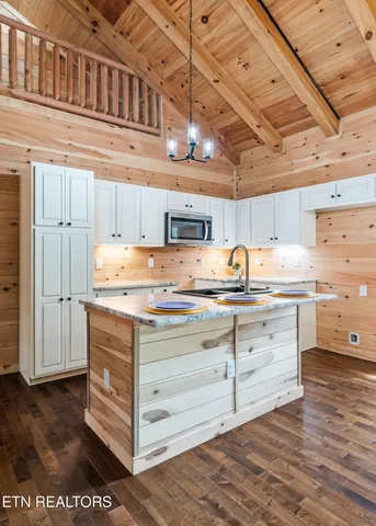 a kitchen with granite countertop a stove cabinets and wooden floor