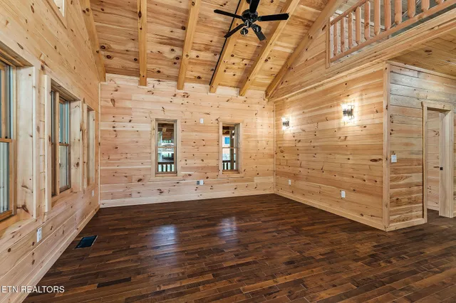 a view of a hallway with wooden floors and chandelier