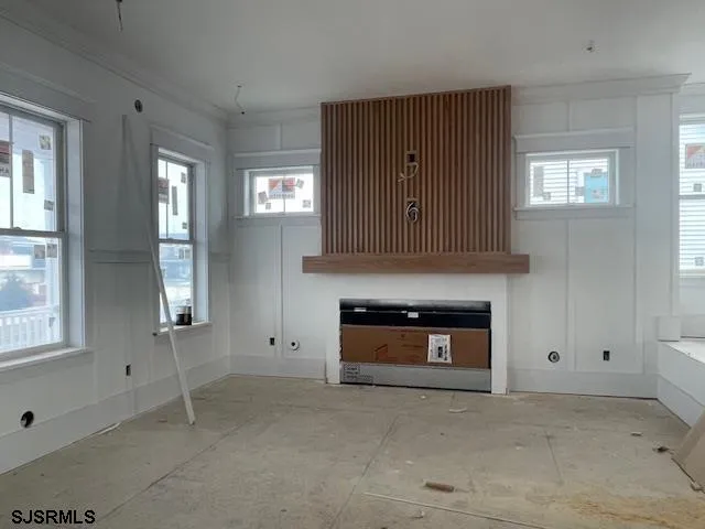 an empty room with windows and fireplace