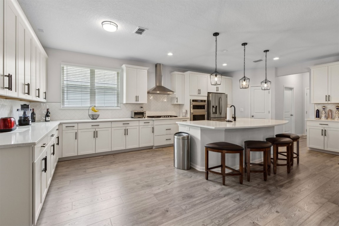 75251 White Rabbit Avenue Yulee, FL 32097 - Photo 18 of 83 a kitchen with kitchen island granite countertop a sink a center island and a window