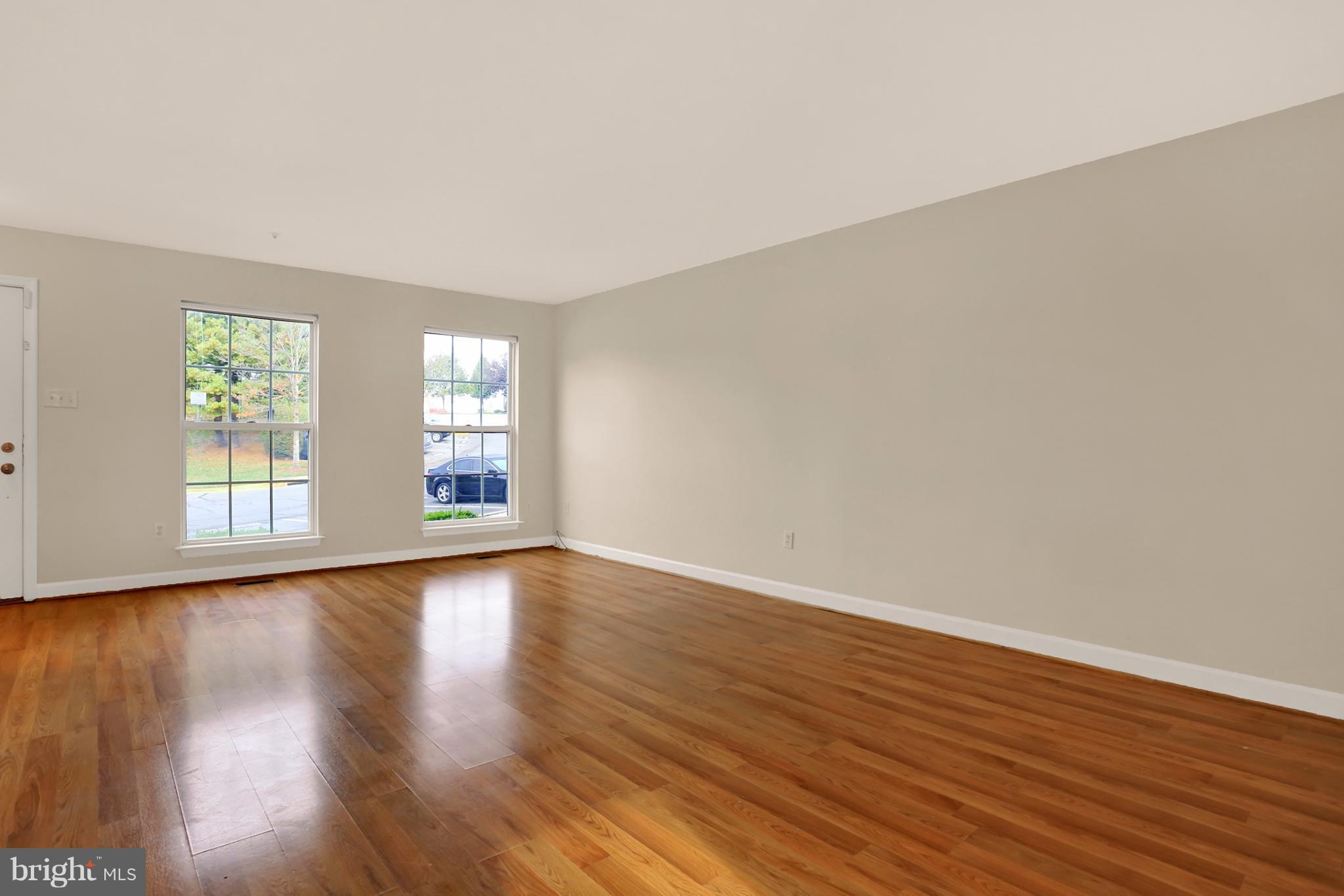 6428 View Point Court Frederick, MD 21703 - Photo 3 of 27 a view of an empty room with wooden floor and a window