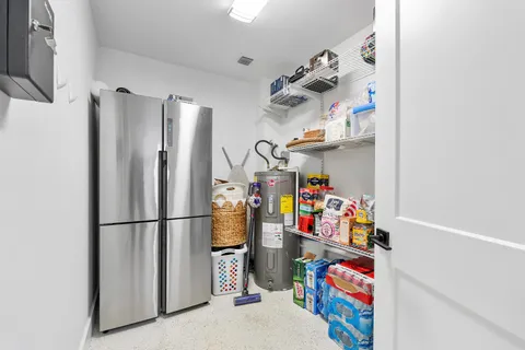 a storage room with lots of clutter and refrigerator